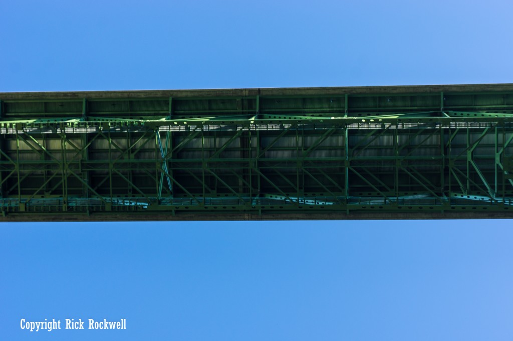 Directly underneath the bridge. 